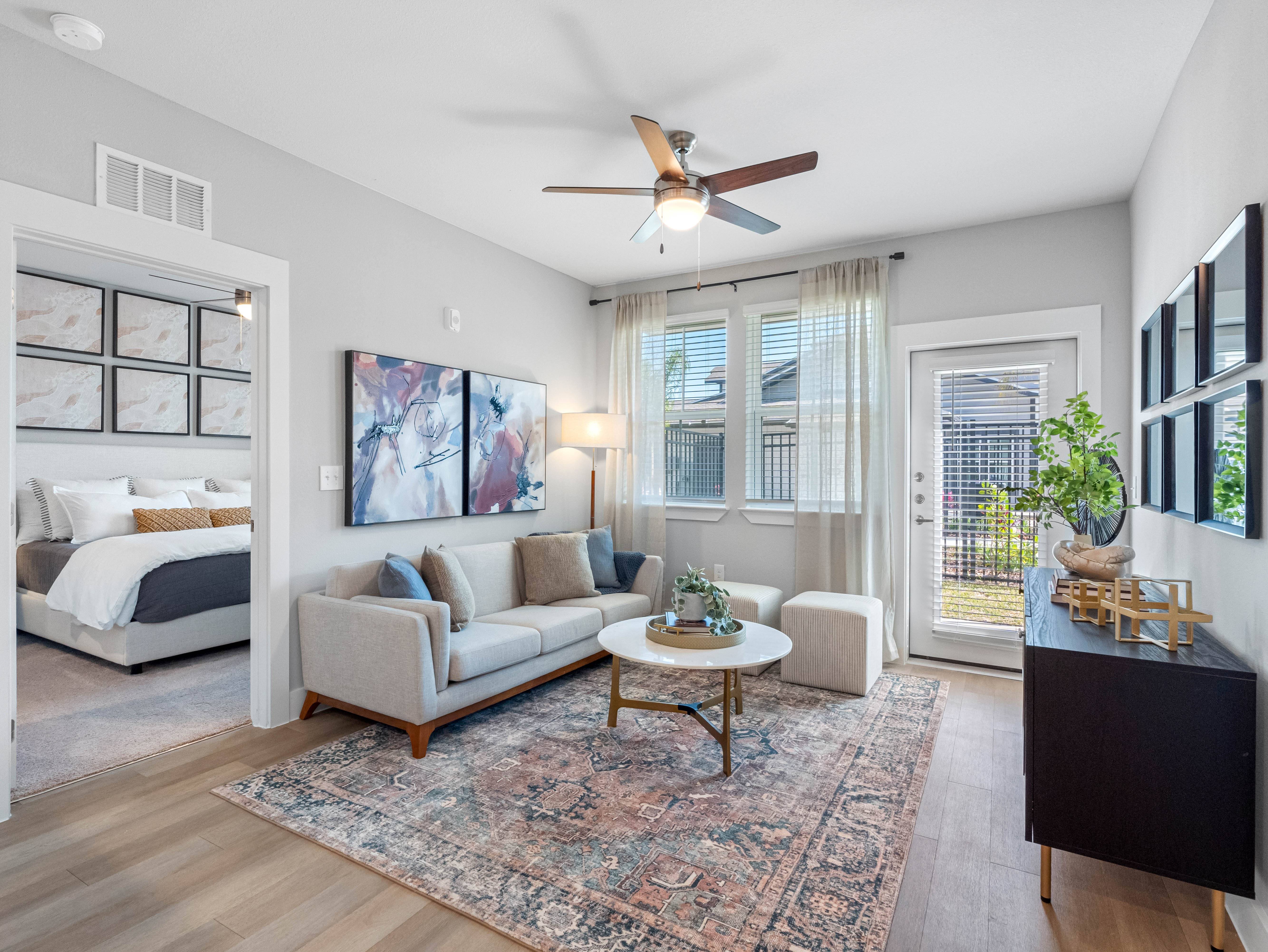 A living room with a couch, a coffee table, and a ceiling fan.